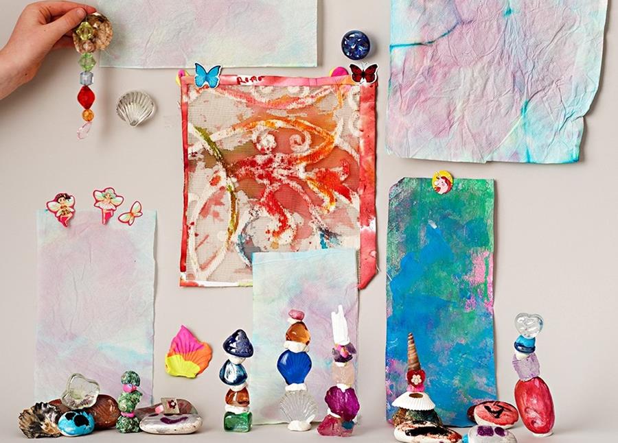 A colorful display of rocks and trinkets with small paintings in the background